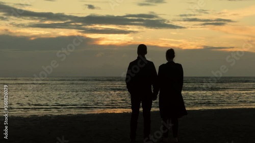 Couple at the beach watching the sunset - 4K