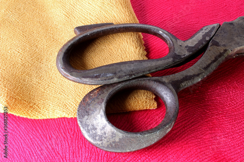 old tailor scissors on fabric background