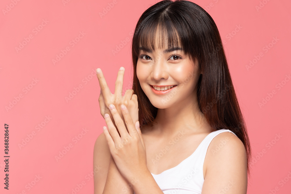 Beautiful Asian woman smile hold hands with clean and fresh skin Happiness and cheerful with positive emotional,isolated on pink background,Beauty Cosmetics and spa Treatment Concept Beautiful Asian woman smile hold hands with clean and fresh skin Happiness and cheerful with positive emotional,isolated on pink background,Beauty Cosmetics and spa Treatment Concept