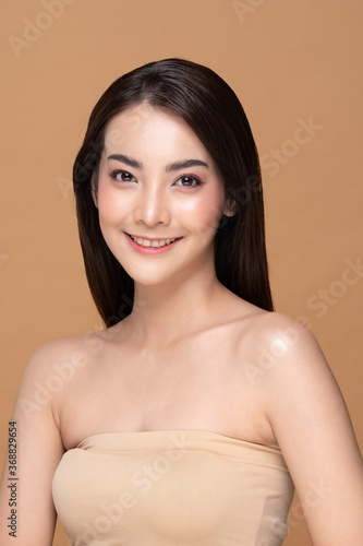 Beautiful Asian woman looking at camera smile with clean and fresh skin Happiness and cheerful with positive emotional,isolated on Beige background,Beauty Cosmetics and spa Facial treatment Concept