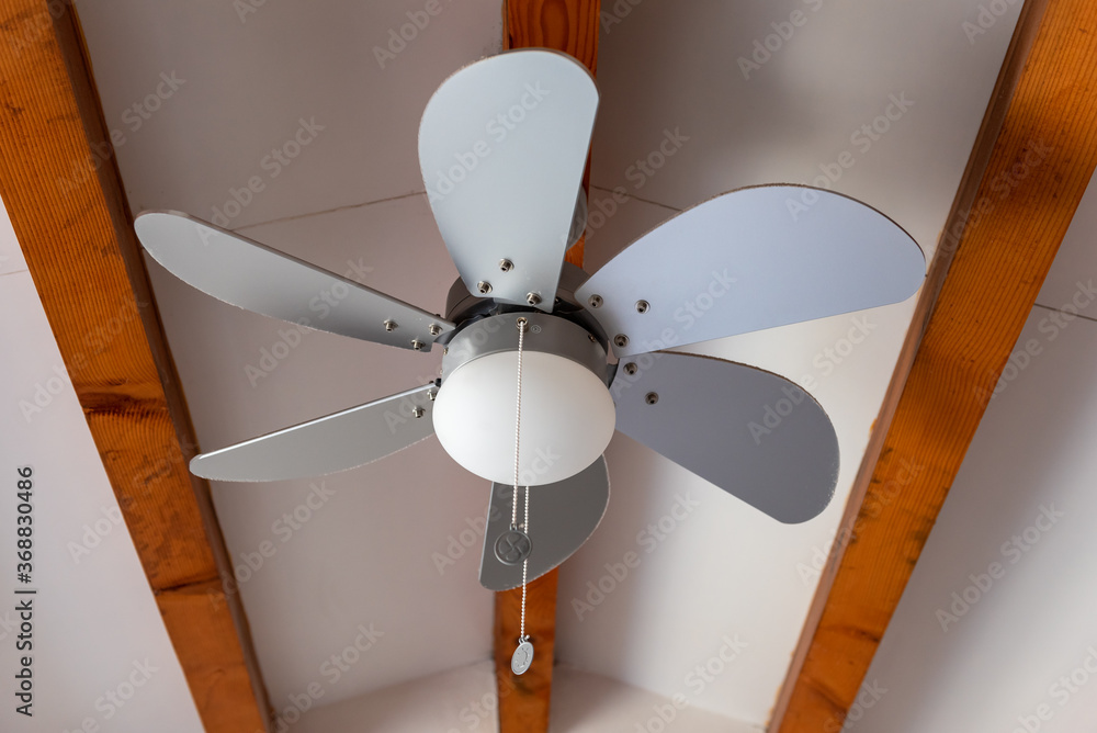 Electric ceiling fan at the room for hot summer days