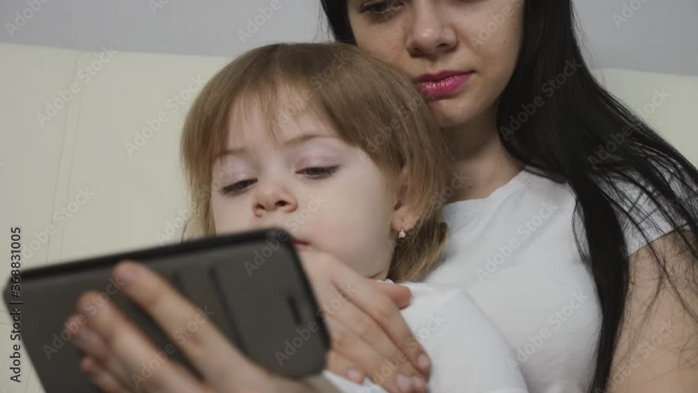 The family sits at home and uses a smartphone to communicate. Mother and daughter in isolation in quarantine.
