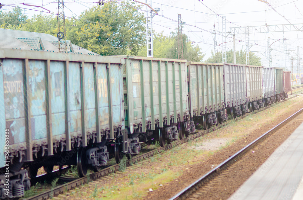 he freight train stands on the rails. People are passing by he freight train stands on the rails. People are passing by