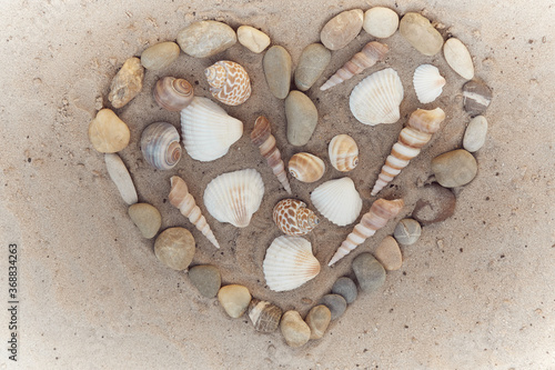 a heart of shells and stones on the beach