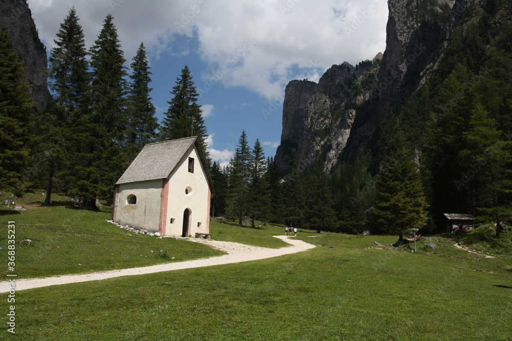 panoramic view of the meadows and mountains of the sella group in alta badia. Chapel of San Silvestro