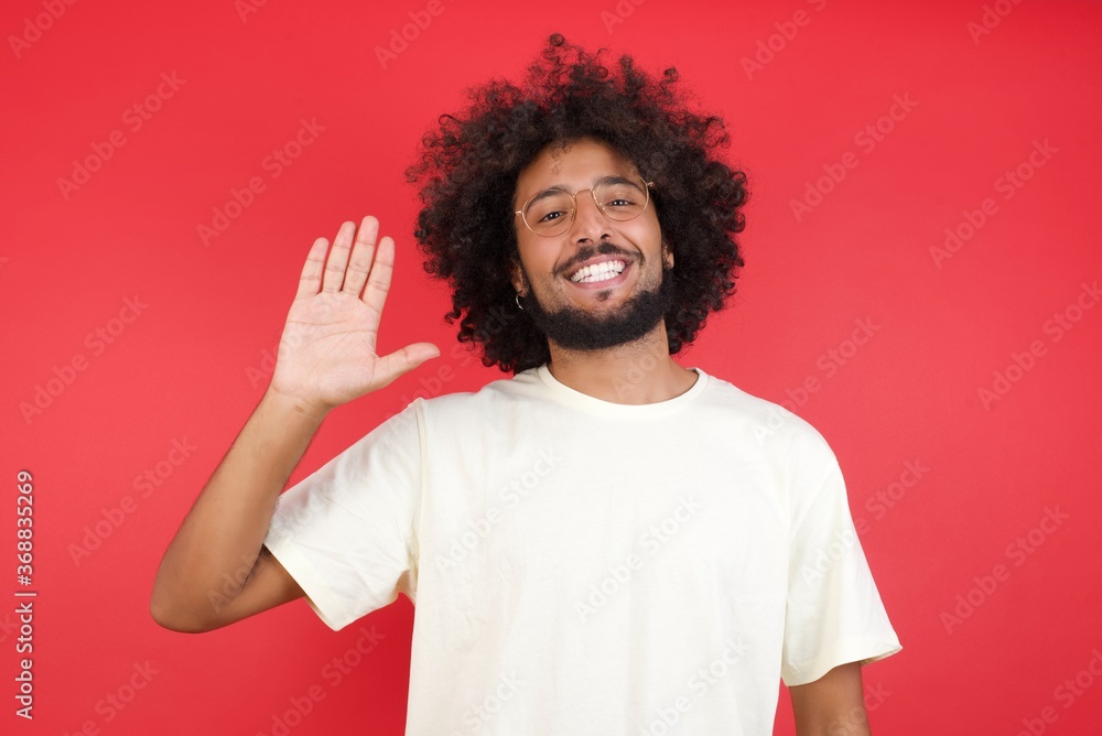 Young handsome man standing over yellow isolated background Waiving saying hello or goodbye happy and smiling, friendly welcome gesture Young handsome man standing over yellow isolated background Waiving saying hello or goodbye happy and smiling, friendly welcome gesture