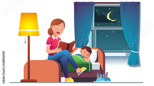 Mother reading bedtime story book to son kid