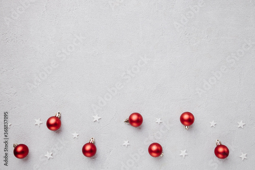 Winter holiday vibes. Border made of festive decorations, baubles and snowflakes on grey background. Seasonal background, Christmas, New Year composition. Flat lay, copy space