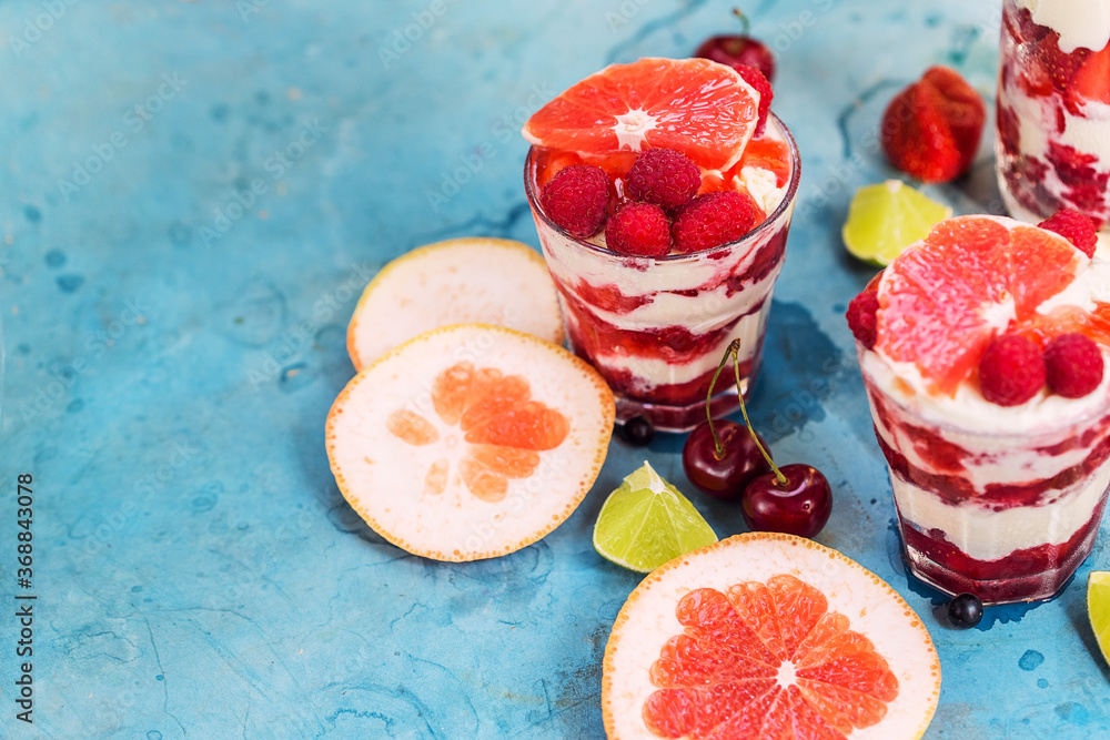 Dessert with raspberry, ice cream and grapefruit on old blue table Dessert with raspberry, ice cream and grapefruit on old blue table