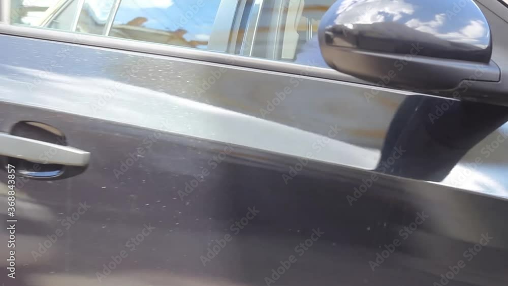 Young caucasian bald man in a blue short sleeve t-shirt gets into a black car. High quality FullHD footage Young caucasian bald man in a blue short sleeve t-shirt gets into a black car. High quality FullHD footage