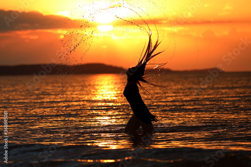 Młoda dziewczyna pozuje do zdjęć w trakcie zachodu słońca