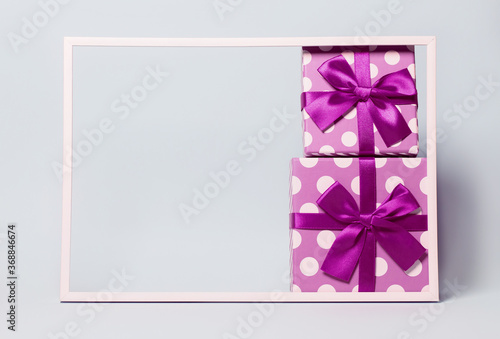 Two present boxes with dots  wrapped with bright ribbon on colorful background. Festive and holiday theme