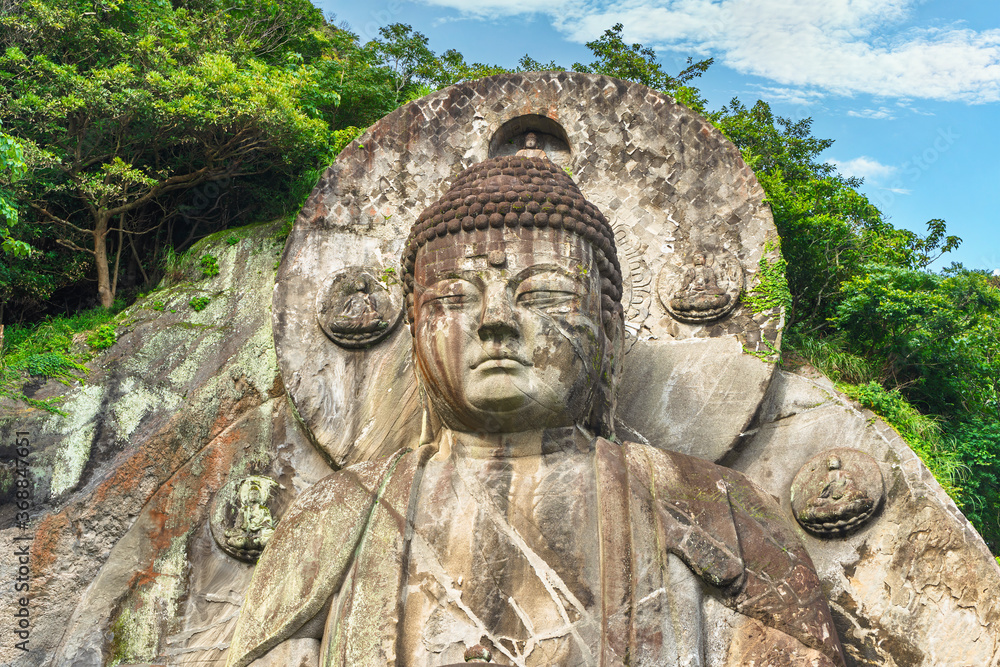 Obraz premium Close-up on the head of the largest stone-carved magaibutsu statue of giant buddha Daibutsu Yakushi of Nihonji temple on the mountain sides of Mount Nokogiri stone quarry.