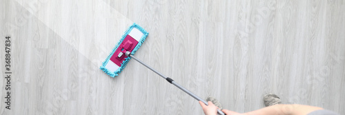 Quadro su tela Male hant hold plastic mop and wash dirty ploor closeup background