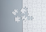Unfinished white jigsaw puzzle pieces on gray background