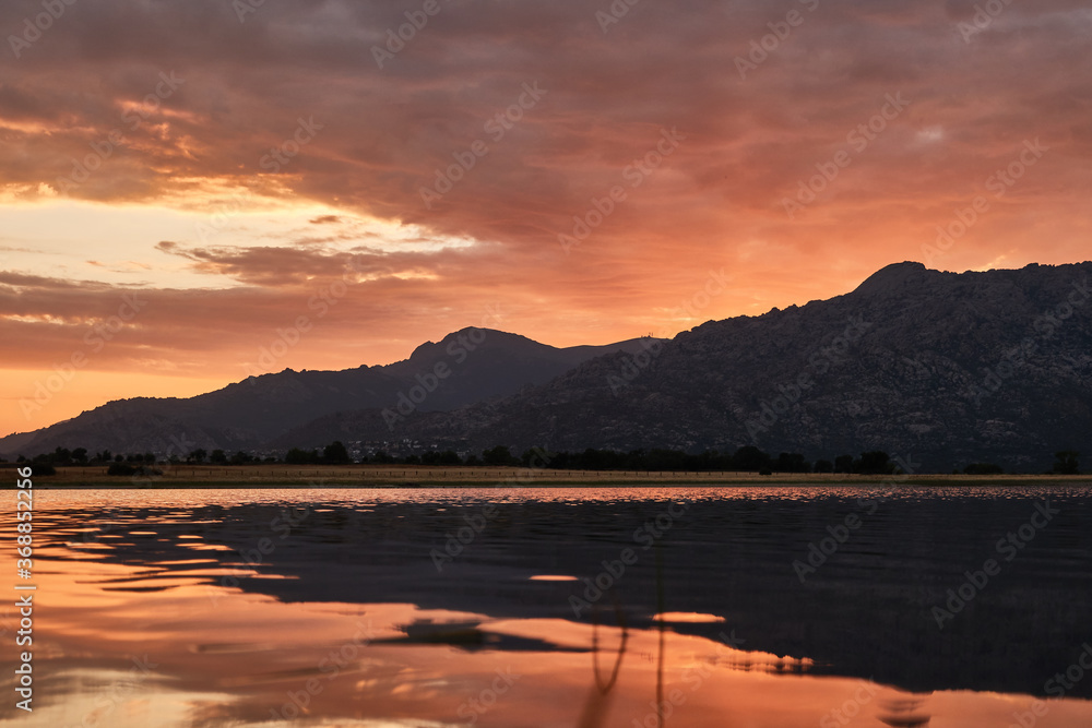 Sunset in the Santillana Reservoir with La Pedriza and the Sierra de Guadarrama in the background. Madrid's community. Spain