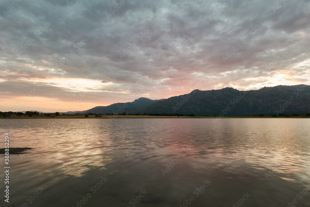 Sunset in the Santillana Reservoir with La Pedriza and the Sierra de Guadarrama in the background. Madrid's community. Spain