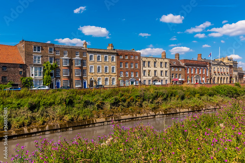 A view along the River Nene towards Georgian buildings on the North Brink in Wisbech, Cambridgeshire in the summertime photo