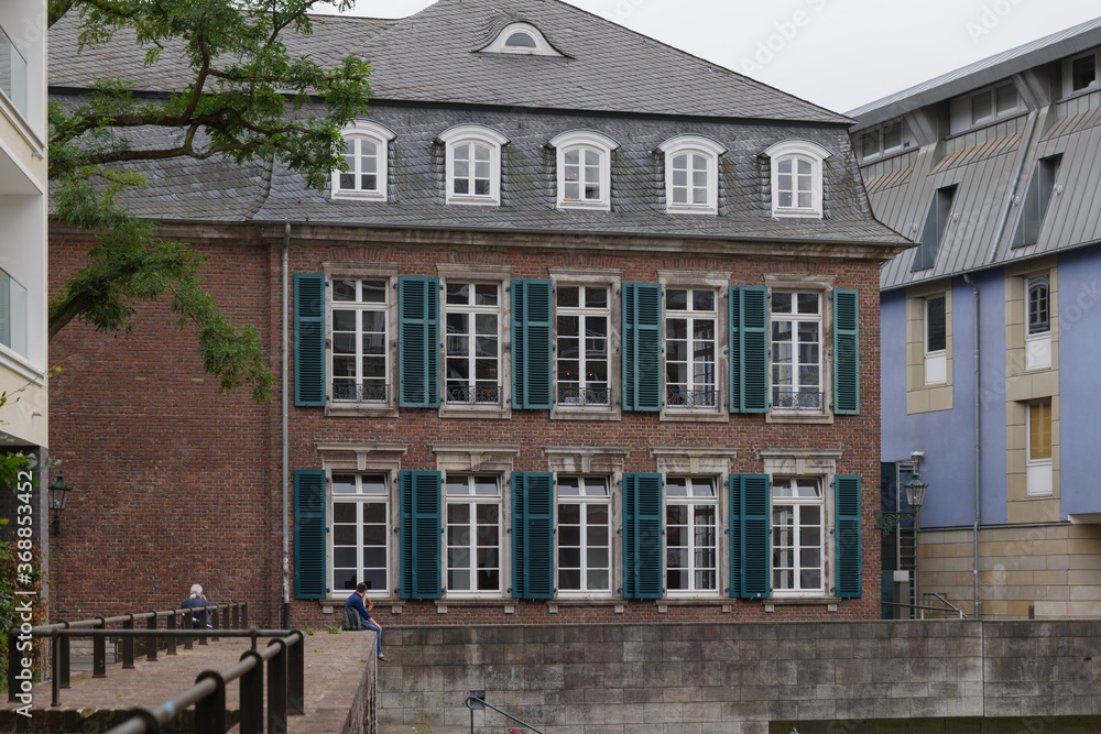 Outdoor exterior view of vintage brick facade with beautiful windows of Catholic church nearby old harbour which connect to Rhine river in Düsseldorf, Germany. 