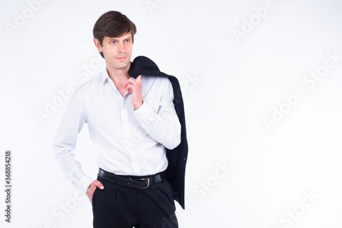 A man in a white shirt and business suit. The man slung his jacket over his shoulder. Portrait of a middle-aged man on a white background. A person in a free pose.