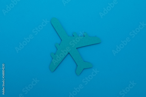 Flat lay design of travel concept with plane and cloud on blue background