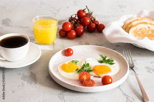 fried eggs with tomatoes and herbs, toast, coffee and juice