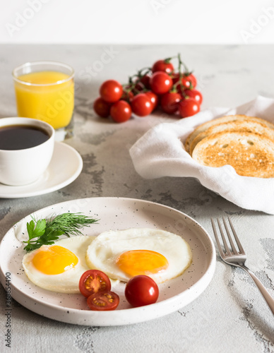 fried eggs with tomatoes and herbs, toast, coffee and juice
