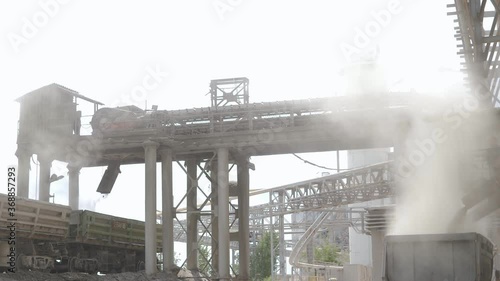Cement production factory on mining quarry. Conveyor belt of heavy machinery loads stones and gravel