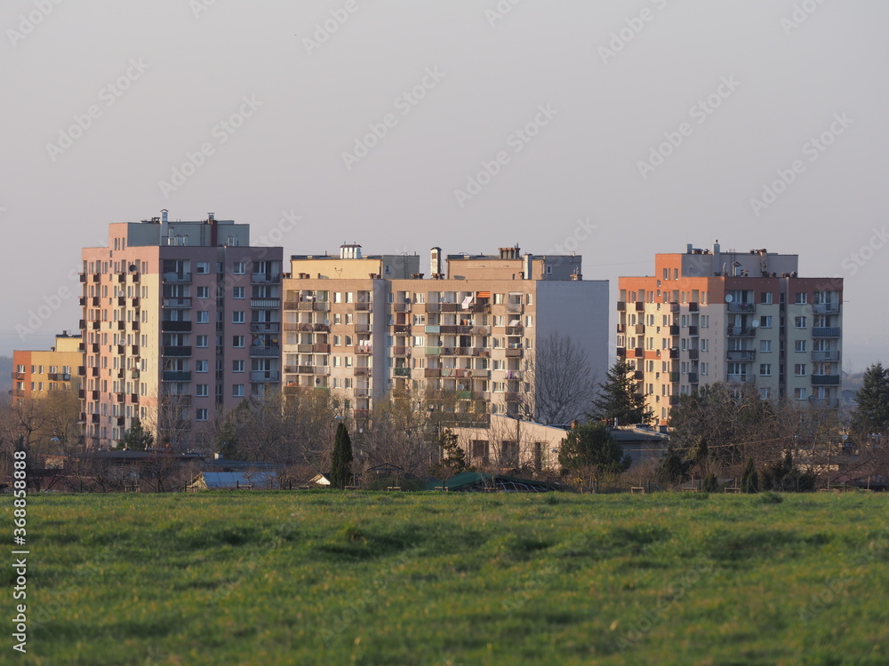 Grassy meadow and blocks of flats at european Bielsko-Biala city in Silesian district in Poland, clear blue sky in 2020 warm sunny spring day on April.