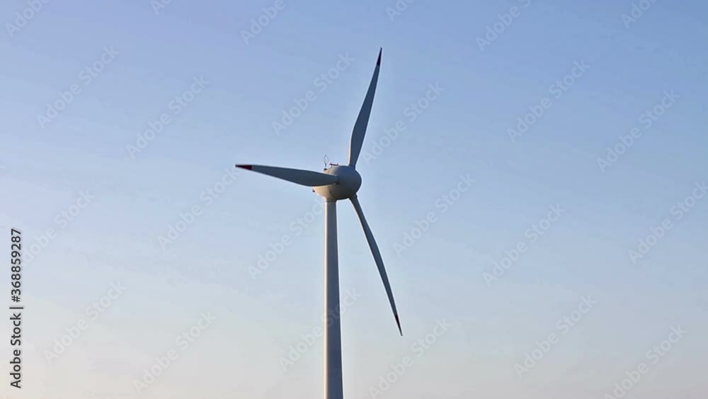 Holic turbines rotating in the wind, blue sky, without nuances, medium shot