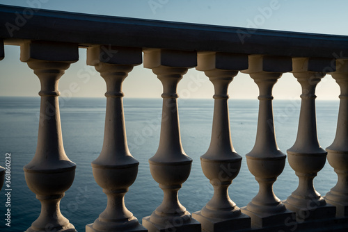 Classic balustrade on the embankment against the sea. White balcony over the sea. Promenade with a beautiful view of the sea on a clear day. Close-up of the balustrade by the sea