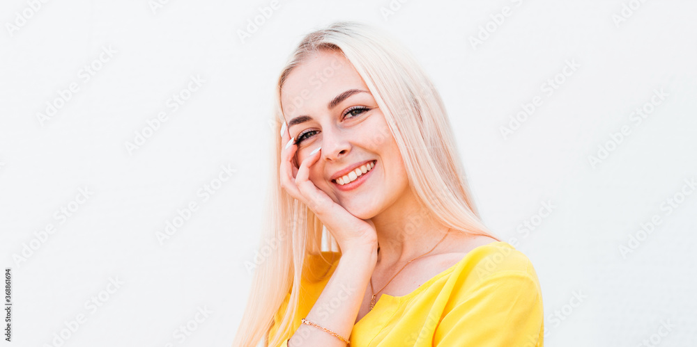Vivacious woman giglling with her eyes screwed up in a moment of fun as she sitting against white studio wall. Happy natural laughing young casual female covering mouth. Human face expressions Vivacious woman giglling with her eyes screwed up in a moment of fun as she sitting against white studio wall. Happy natural laughing young casual female covering mouth. Human face expressions