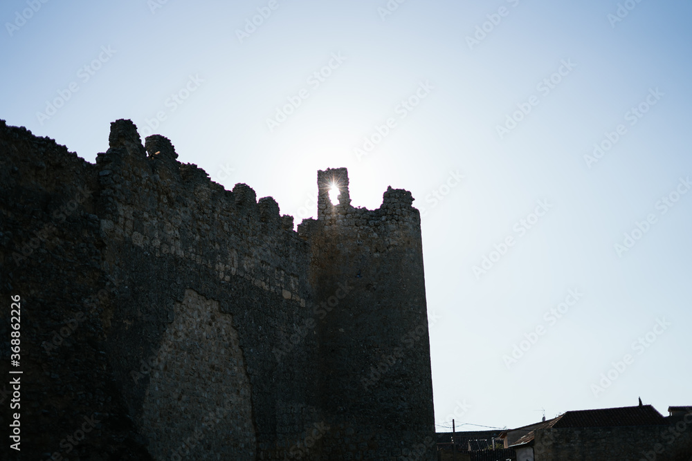 sun light through the battlement of an ancient castle stone wall
