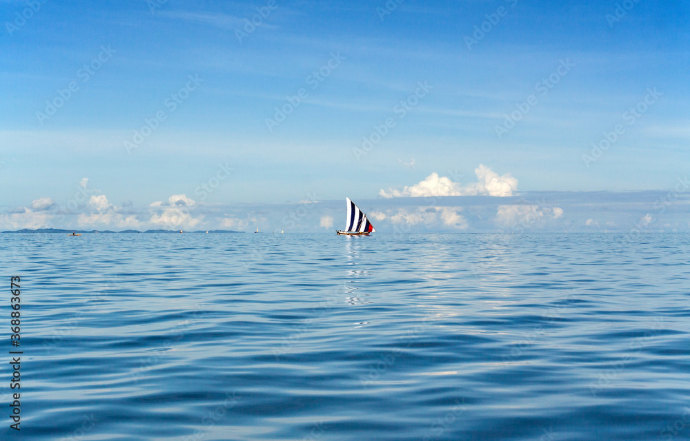 NOSY BE, MADAGASCAR: Traditional sailing boat on the Indian Ocean, blue sky and coean.