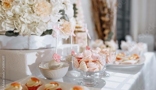 Candy bar at the banquet. Wedding table with sweets, cake, pastries, muffins, sugar treats. Event in the restaurant