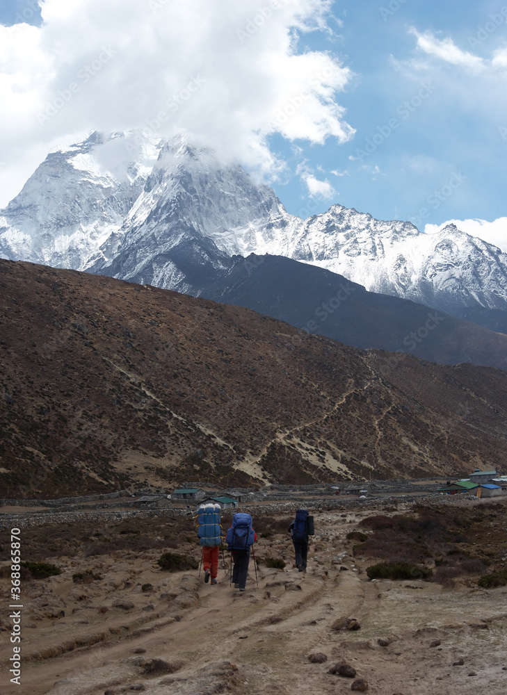 Trekkers at Everest trail with snow mountain in background, Himalaya, Nepal