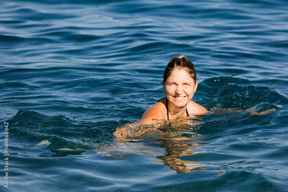 Happy woman swimming in sea