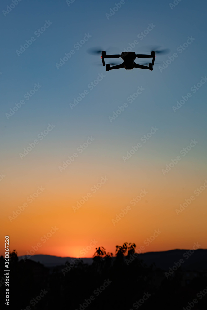 Photo of a drone flying in the air in the sunset light
