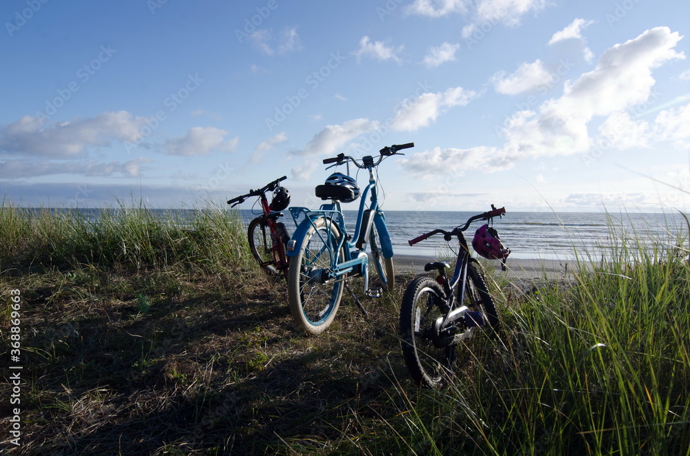 Bicycles and helmets parked over sand beach in Westport Bicycles and helmets parked over sand beach in Westport