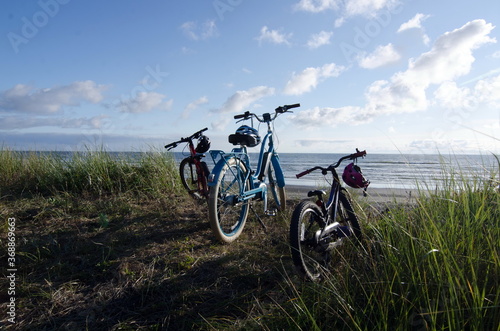 Bicycles and helmets parked over sand beach in Westport