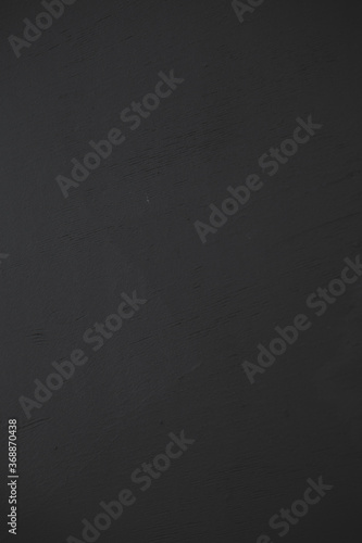 Black matte wood wall texture background, close up