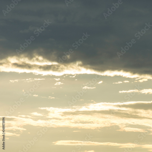 Fototapeta Naklejka Na Ścianę i Meble -  Cloudy mood over Lake Garda in Italy. Dark clouds against the bright sky. A bird flies lonely across the sky. Scraps of cloud spread out. Evening mood.