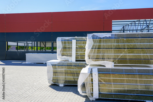 a pile of sandwich facade panels on the construction site of a new metal frame building photo