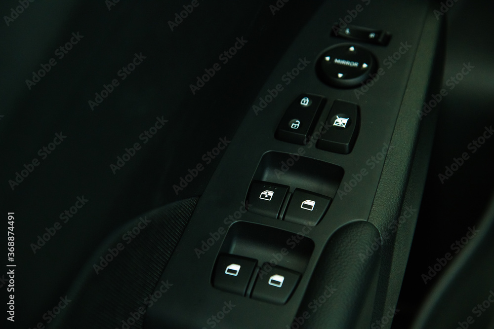 Car interior details of door handle with windows controls and adjustments. Car window controls Car interior details of door handle with windows controls and adjustments. Car window controls
