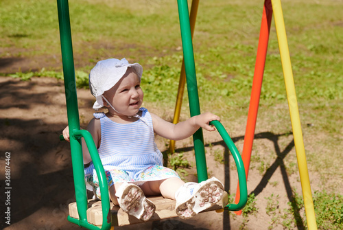 A baby rides on a swing. A baby have a fun on a flip-flap in the park © etonastenka