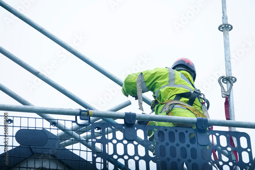Картината върху платно Scaffold worker dismantling access structure on construction building site