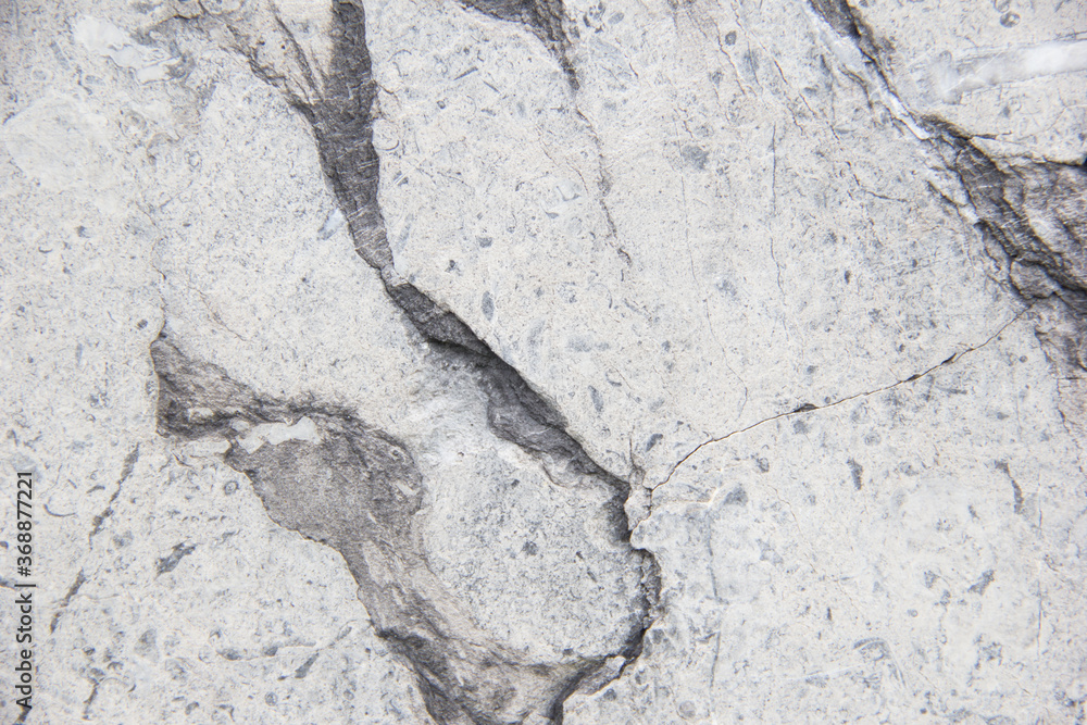 Light natural stone with cracks. Marble texture. Grey stone background. Light natural stone with cracks. Marble texture. Grey stone background.