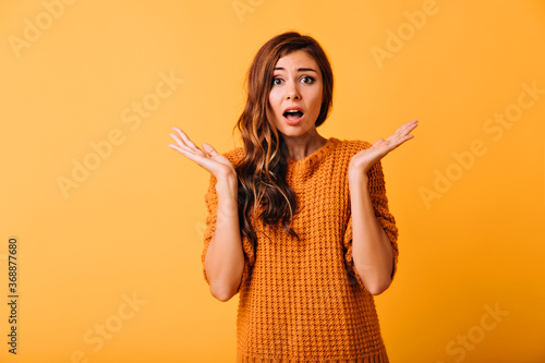 Attractive dissapointed woman posing on yellow background. Emotional caucasian girl waving her hands. photo