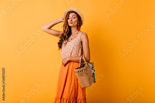 Jocund woman in summer skirt posing with kissing face expression. Indoor photo of relaxed elegant ginger lady enjoying leisure time in studio.