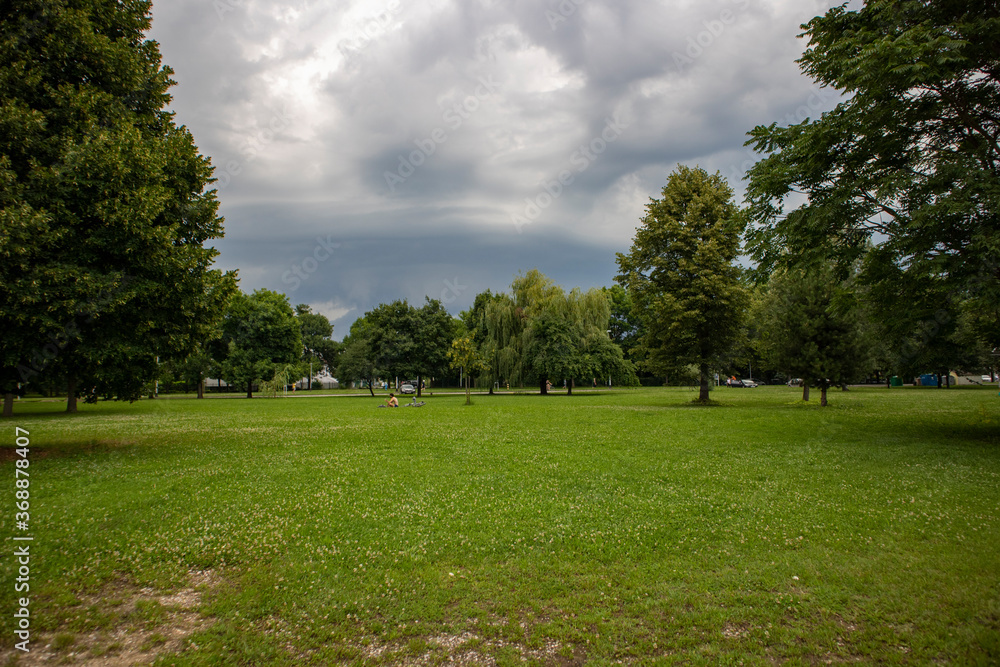 Rain and hail clouds gathering over zagreb city, fast approaching over the shore of Jarun lake, popular spot for relaxation, sports and casual recreation in the green environment Rain and hail clouds gathering over zagreb city, fast approaching over the shore of Jarun lake, popular spot for relaxation, sports and casual recreation in the green environment